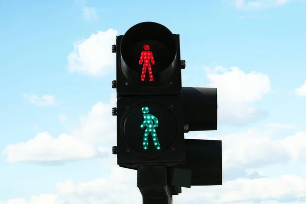 Traffic lights with green sign against blue sky. Road rules