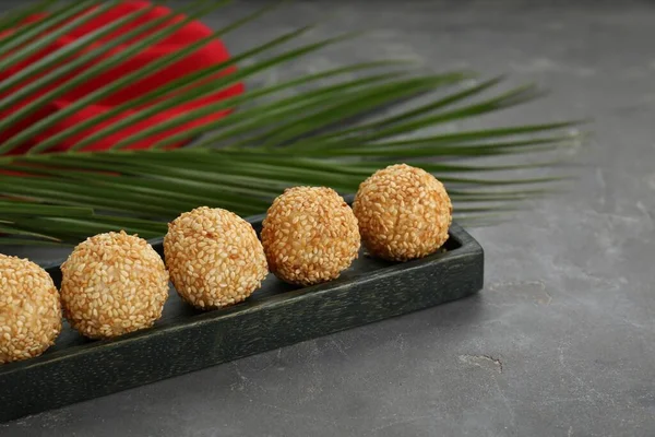 Delicious sesame balls and green leaf on grey table