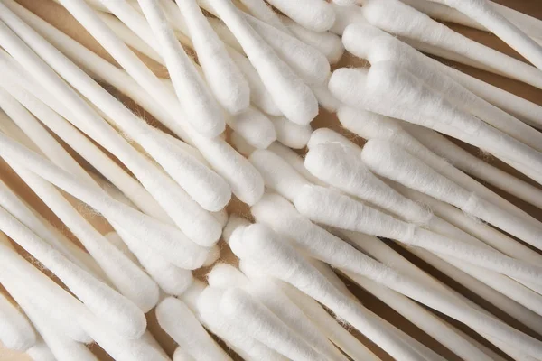 Many clean cotton buds on beige background, top view