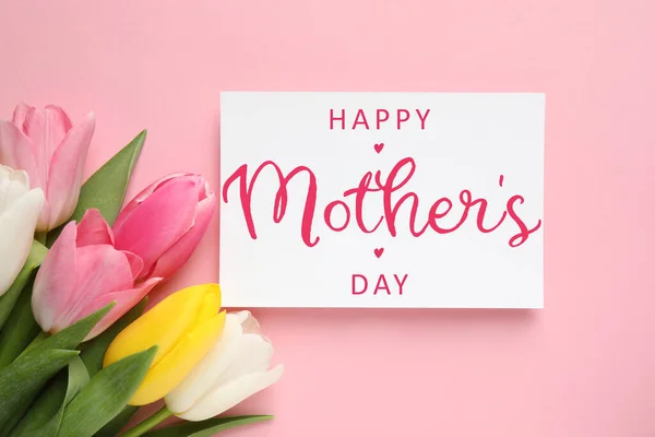 Happy Mother\'s Day greeting card and beautiful tulip flowers on pink background, flat lay