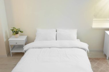White soft pillows on cozy bed in room