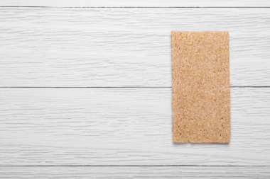Fresh crunchy rye crispbread on white wooden table, top view. Space for text