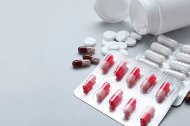 Different antidepressants and medical bottle on grey background, closeup. Space for text