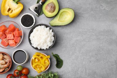 Ingredients for poke bowl on grey table, flat lay. Space for text