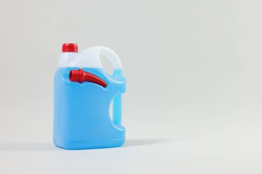 Plastic canister with nozzle and blue liquid on light grey background, space for text