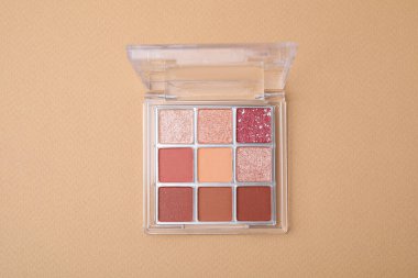 Beautiful eye shadow palette on beige background, top view