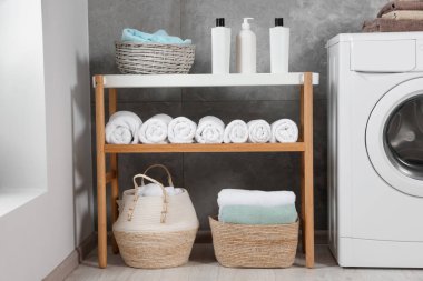 Many soft terry towels and washing machine in bathroom