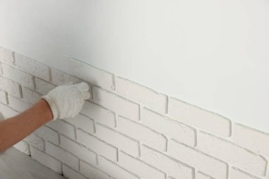 İşçi odaya dekoratif duvar kiremitleri yerleştiriyor, yakın plan