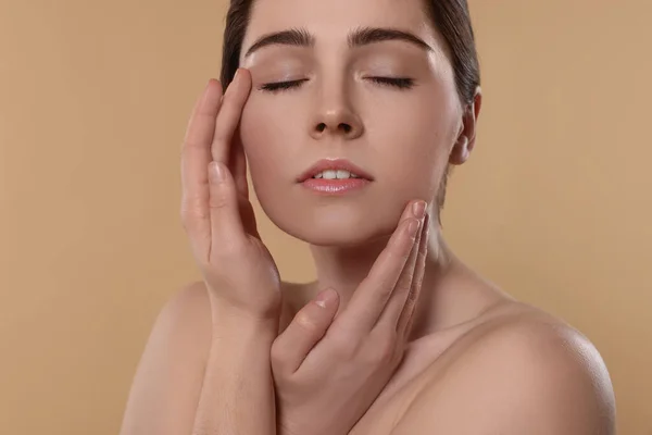 Young Woman Massaging Her Face Beige Background — Fotografia de Stock
