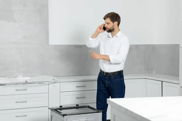 Man Talking Smartphone Empty Kitchen Space Text — стоковое фото