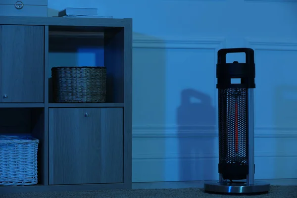 Electric infrared heater in dark room at night