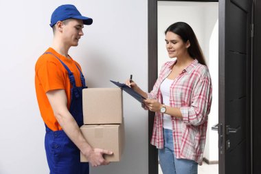 Woman receiving parcels from courier at home