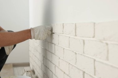 İşçi odaya dekoratif duvar kiremitleri yerleştiriyor, yakın plan