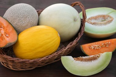 Many tasty ripe melons on wooden table