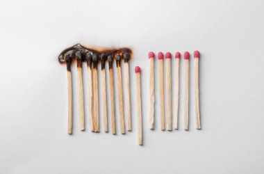 Burnt and whole matches on white background, flat lay