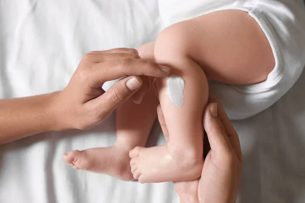 Mother Applying Moisturizing Cream Baby Leg Bed Top View — Stockfoto