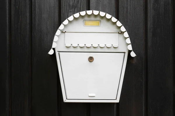 White metal letter box on wooden door outdoors