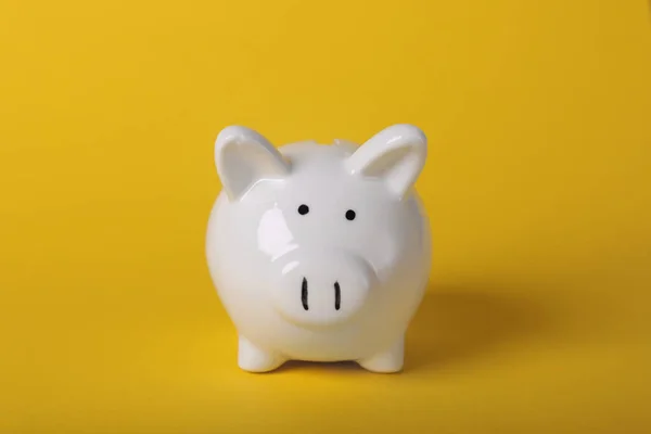 Ceramic piggy bank on yellow background. Financial savings