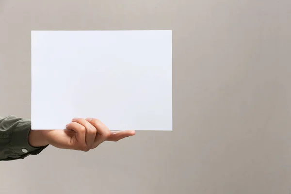Man Holding Sheet Paper Grey Background Closeup Mockup Design — Stockfoto