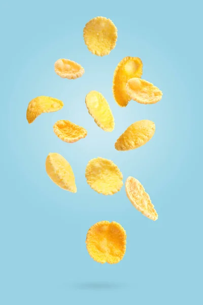 Many Tasty Corn Flakes Falling Light Blue Background — Stock Photo, Image