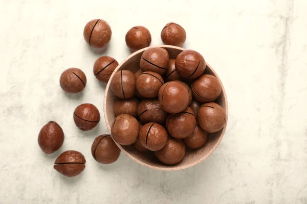 stock image Delicious organic Macadamia nuts on light gray table, flat lay