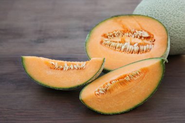 Tasty orange ripe melons on wooden table