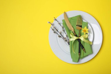 Söğüt dalları ve sarı arkaplandaki yazı için alanı olan şenlikli masa ayarları, üst görünüm. Paskalya kutlaması