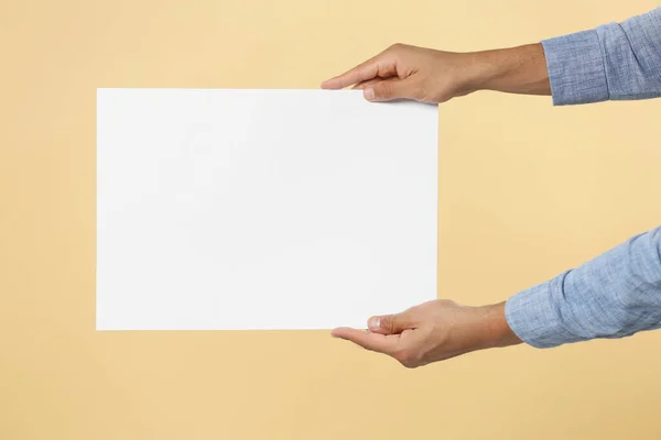 Man Holding Sheet Paper Beige Background Closeup Mockup Design — Stock Fotó
