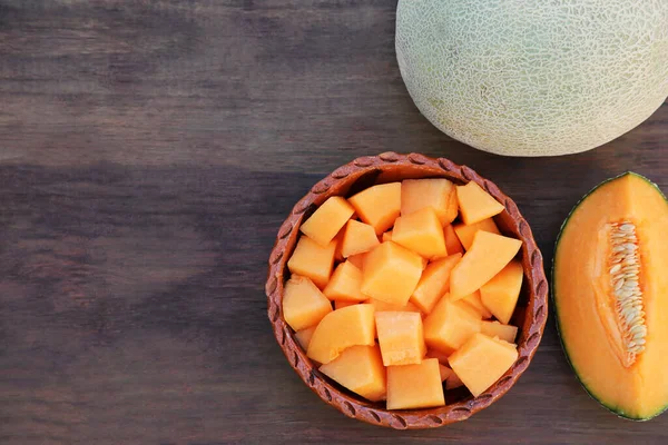 stock image Whole and cut delicious ripe melons on wooden table, flat lay. Space for text