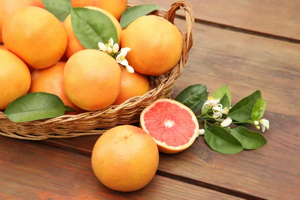Weidenkorb Mit Frischen Grapefruits Und Grünen Blättern Auf Holztisch — Stockfoto