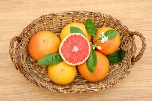 Fonott Kosár Friss Érett Grapefruitokkal Zöld Levelekkel Asztalon Felülnézetből — Stock Fotó