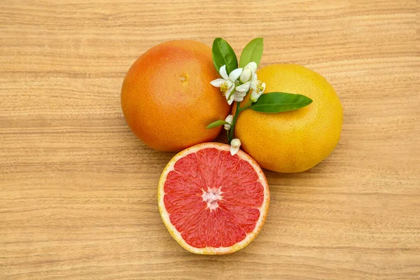 Fresh Ripe Grapefruits Flowers Green Leaves Wooden Table Top View — Stock Photo, Image