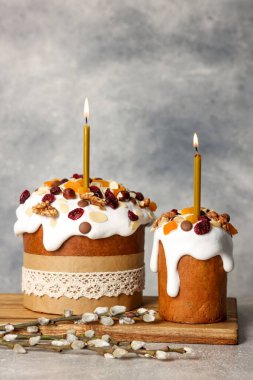 Tasty Easter cakes and willow branches on grey table