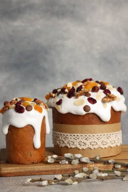 Tasty Easter cakes and willow branches on grey table