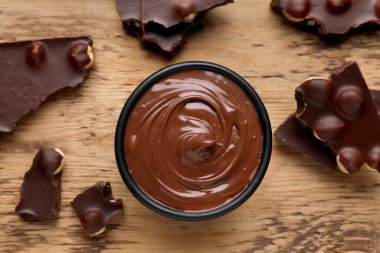 Çikolata parçaları ve bir kase tatlı ezme tahta masanın üzerinde, düz yatıyordu.