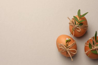 Festively decorated chicken eggs on light grey background, flat lay with space for text. Happy Easter