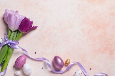 Bayramlık Paskalya yumurtaları ve renkli arka planda güzel lalelerle bezenmiş düz bir kompozisyon. Metin için boşluk