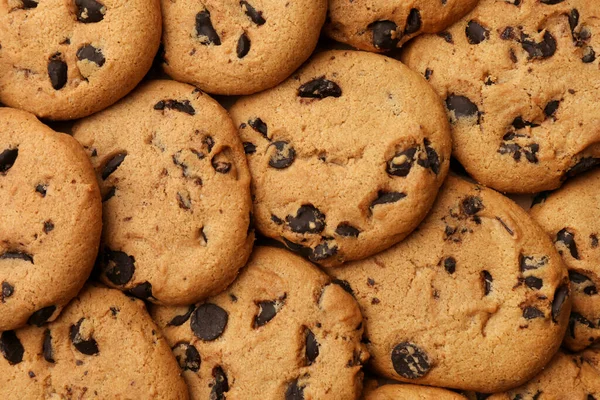 stock image Delicious chocolate chip cookies as background, top view