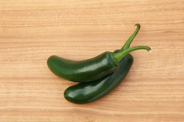 stock image Fresh green jalapeno peppers on wooden table, top view