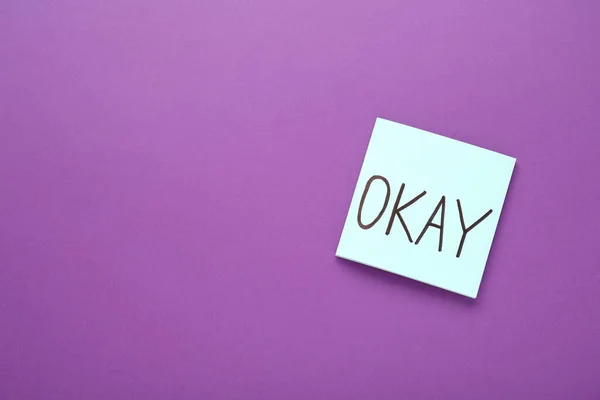 stock image Note with word Okay on purple background, top view. Space for text