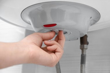Kadın içeride maksimum enerji verimliliği göstergesi ayarlıyor, yakın plan. Kazan kurulumu