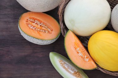 Tasty ripe melons on wooden table, flat lay