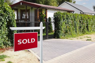 Red Sold sign near beautiful house outdoors