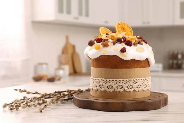 stock image Delicious Easter cake with dried fruits and willow branches on white marble table in kitchen. Space for text