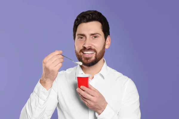 Bonito Homem Com Delicioso Iogurte Colher Fundo Violeta — Fotografia de Stock