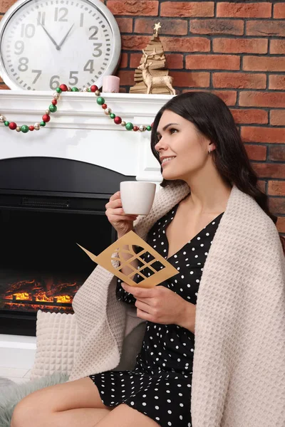 Young Woman Greeting Card Hot Drink Sitting Fireplace Indoors — Stok fotoğraf