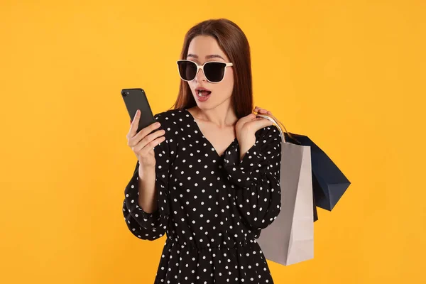 Mujer Joven Sorprendida Con Bolsas Compras Mirando Teléfono Inteligente Sobre —  Fotos de Stock