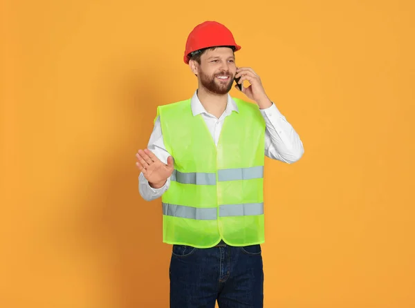 Man Reflective Uniform Talking Smartphone Orange Background — Stock Photo, Image