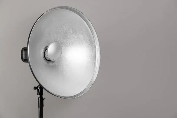 专业的美盘反射镜在三脚架上的灰色背景 空间为文字 摄影设备 — 图库照片