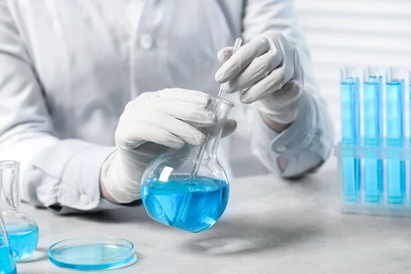 Wissenschaftler Nimmt Probe Hellblauer Flüssigkeit Weißem Tisch Labor Nahaufnahme — Stockfoto